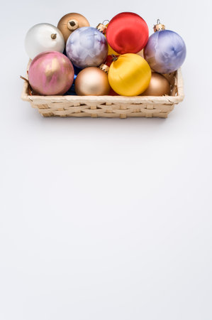 Multicolored Christmas decorative balls in a wicker canister with sapce for textの写真素材