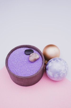 vase with colored sand and Christmas ball decorations on a white background with copy spaceの写真素材