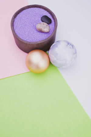 vase with colored sand and Christmas ball decorations on a white background with copy spaceの写真素材