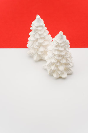 Christmas ornamental background with fir trees on a red and white surface with copy spaceの写真素材