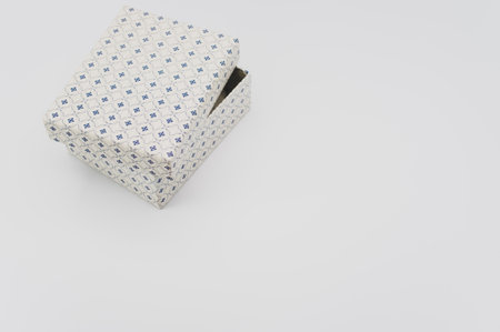 a closed white paperboard decorated box on white background with text spaceの写真素材