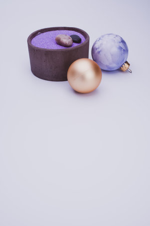 vase with colored sand and Christmas ball decorations on a white background with copy spaceの写真素材