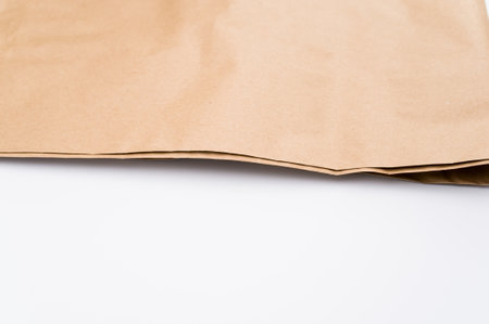 natural food paper bag folded on a white surface with text spaceの写真素材