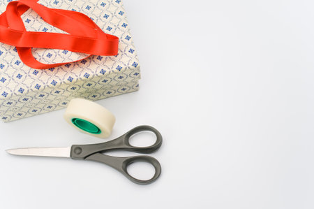 decorated cardboard box and red ribbon on white background with text spaceの写真素材