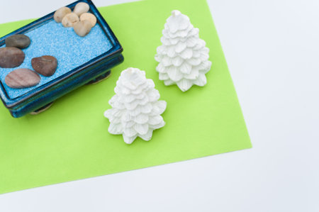 isolated terracotta vases with decorative sand and trees on green paper with space for text
