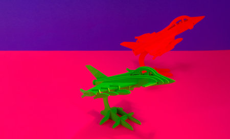 Green and red airplane models on purple and pink backgrounds