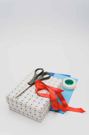 a closed white cardboard decorated box with stationery on white background with text spaceの写真素材
