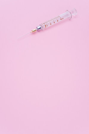 an isolated injection syringe on mauve paper background with text spaceの写真素材