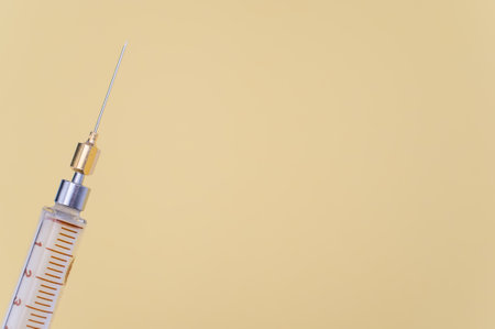 an isolated injection syringe on yellow paper background with text spaceの写真素材
