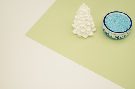 Christmas ornamental background with fir trees and vase with sand on a white green surface with copy spaceの写真素材
