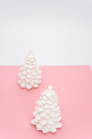 Christmas ornamental background with fir trees on a pink and white surface with copy spaceの写真素材