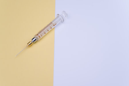 an isolated injection syringe on yellow and white paper background with text space