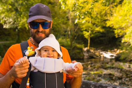 A father with the baby in a backpack heading to Passerelle de Holzarte in the forest or jungle of Irati, north of Navarra in Spain and the Atlantic Pyrenees of Franceの写真素材