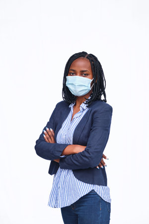 An African American businesswoman standing with her arms crossed against a white backgroundの写真素材