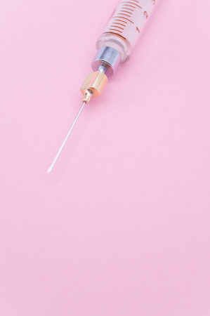 an isolated injection syringe on mauve paper background with text spaceの写真素材
