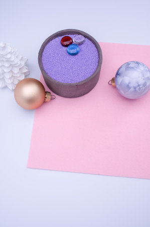 vase with colored sand and Christmas ball decorations on a white background with copy spaceの写真素材