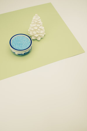 Christmas ornamental background with fir trees and vase with sand on a white green surface with copy...