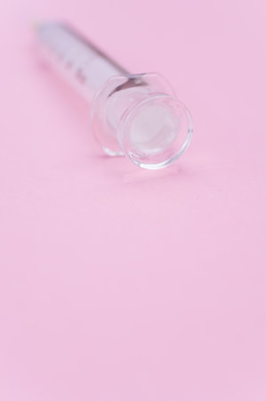 an isolated injection syringe on mauve paper background with text spaceの写真素材
