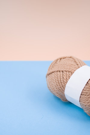 A vertical shot of isolated beige yarn on blue background with text spaceの写真素材