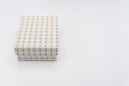 a closed white paperboard decorated box on white background with text space