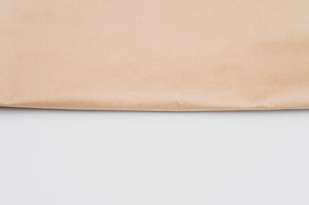 natural food paper bag folded on a white surface with text spaceの写真素材