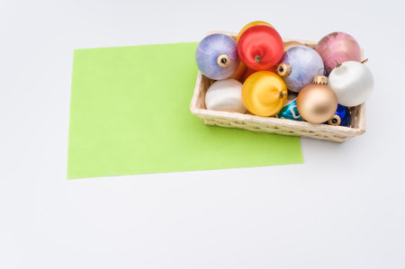 Multicolored Christmas decorative balls in a wicker canister with sapce for textの写真素材