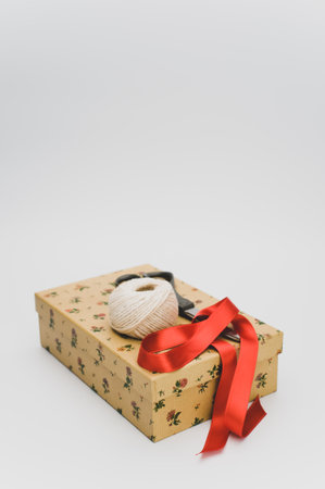 a closed paperboard box with stationery and red ribbon on white background with text spaceの写真素材