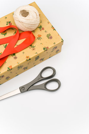 a closed paperboard box with stationery and red ribbon on white background with text spaceの写真素材