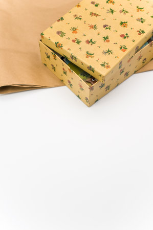 a closed paperboard decorated box on white and kraft paper background with text spaceの写真素材