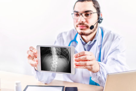 Orthopedic doctor show x-ray radiography on tablet. Concept of rehabilitation and healing physiotherapy.の写真素材