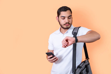 Young entrepreneur checks the time on his watch.