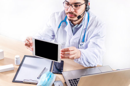 Shot of a doctor showing a patient some information on a digital tabletの写真素材