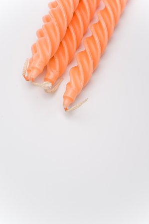 bunch of orange candles on a white surface with space for textの写真素材