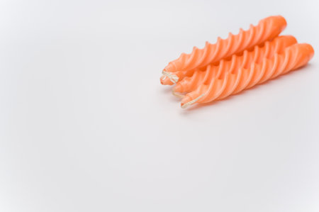 bunch of orange candles on a white surface with space for textの写真素材