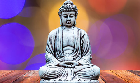 Buddha statue sitting in meditation and colorful blurred background. Selective focus.の写真素材