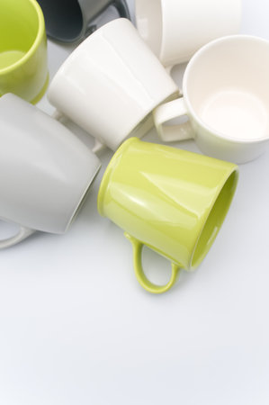 set of multicolored ceramic cups on a white tabletop with copy spaceの写真素材