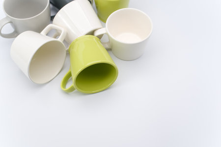 set of multicolored ceramic cups on a white tabletop with copy spaceの写真素材