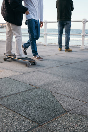 Longboard lessons. Instructor teaching a longboarder on the beach promenadeの写真素材