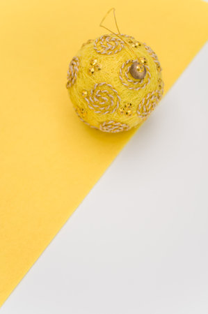 Multicolored Christmas decorative balls with sapce for text on a yellow white surface