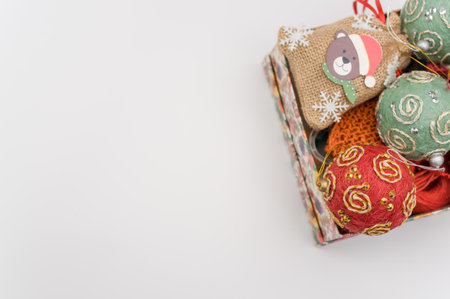 Multicolored Christmas decorative balls and figurines in a box with sapce for textの写真素材