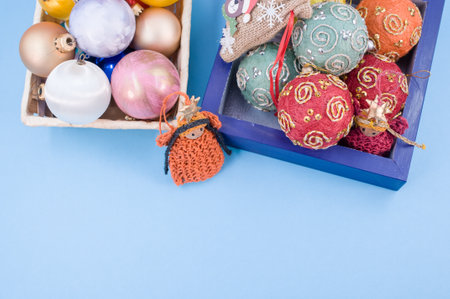 Multicolored Christmas decorative balls and figurines in a blue wooden box with sapce for textの写真素材