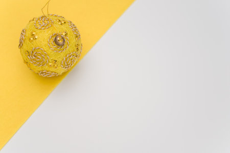 Multicolored Christmas decorative balls with sapce for text on a yellow white surface