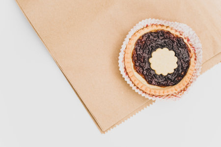 isolated cherry jam tart in a paper backing cup on a white background with text spaceの写真素材