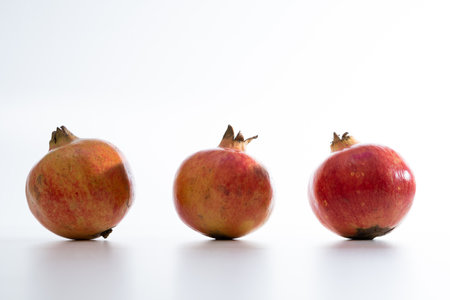 Opened red juicy pomegranate on white backgroundの写真素材
