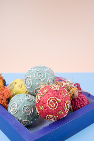 Multicolored Christmas decorative balls and figurines in a blue wooden box with sapce for textの写真素材