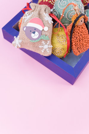 Multicolored Christmas decorative balls and figurines in a blue wooden box with sapce for textの写真素材