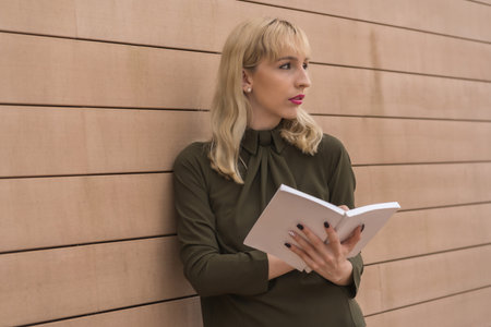 Entrepreneurial business park girl pointing notes in the diary, young blonde in a green shirt...