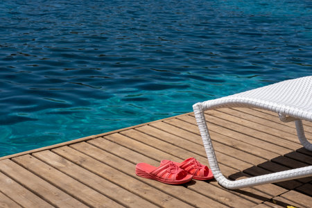 beach slippers standing on wooden floor by the sea