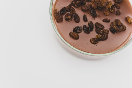 tasty cocoa and chocolate pudding with raisins on top in a bowl with space for textの写真素材
