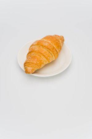 shot of fresh and buttery croissant in a plate on a white background with text spaceの写真素材